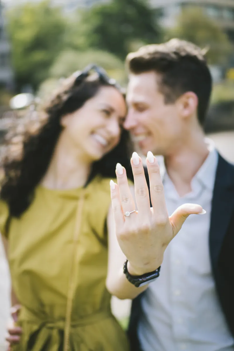 Parmida showing her engagement ring with Jake smiling behind her